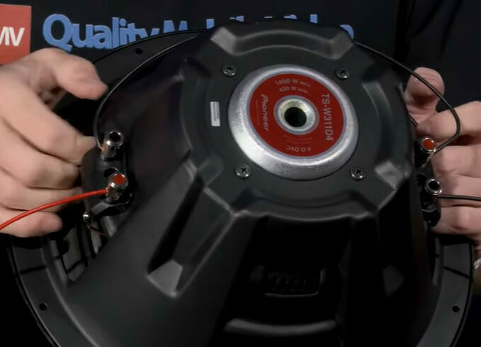 A person holding a dual voice coil sub