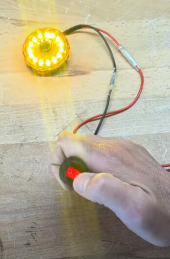 A person is turning on a light using a rocker switch
