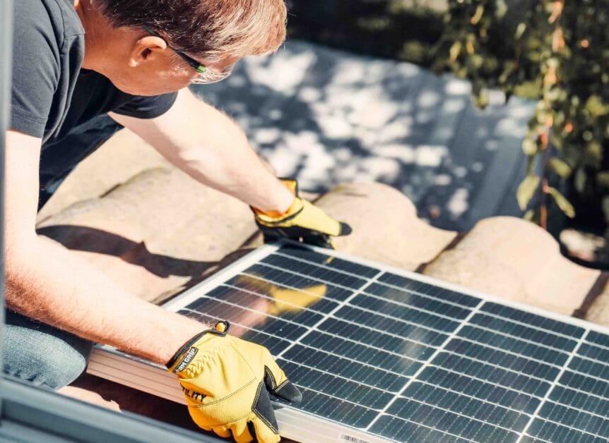 A man with googles and gloves working on a solar panel