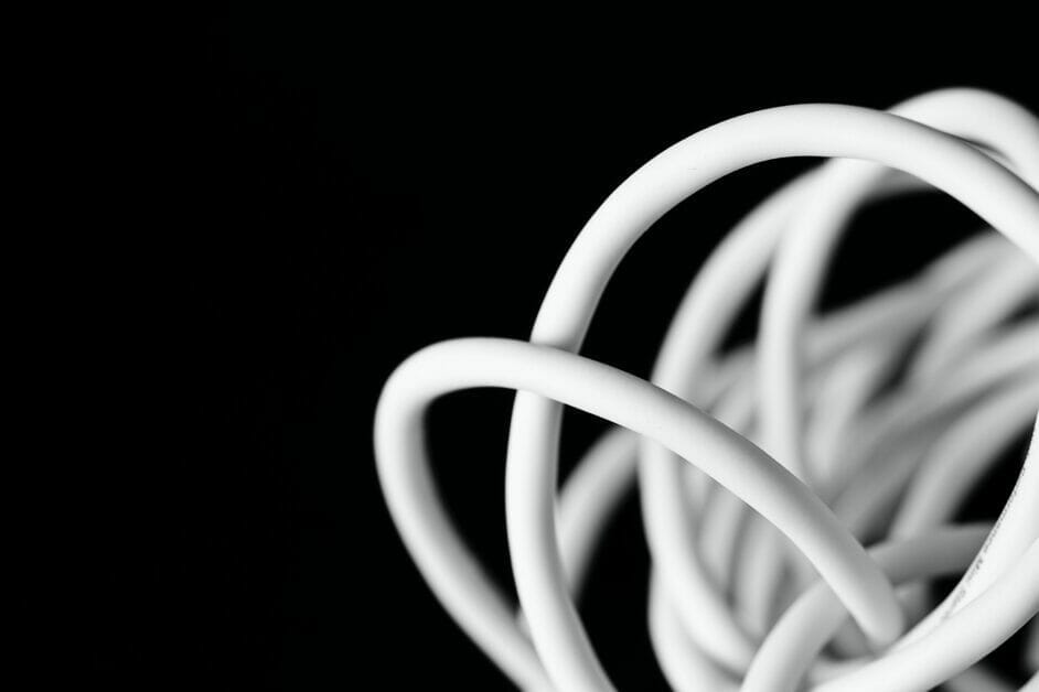A tangled white wire in a black background