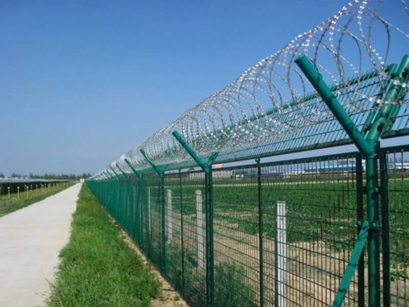 A fence built with barbed wire alongside road