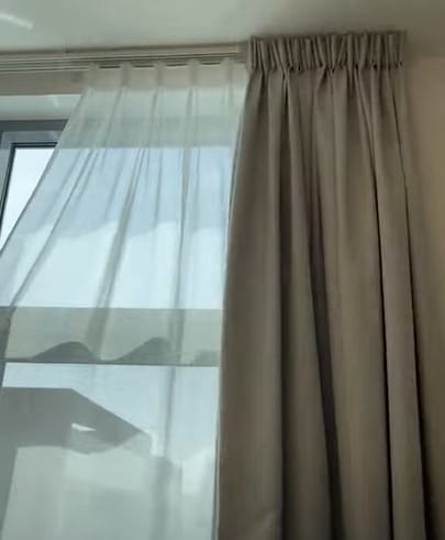 A cream and white curtains on the window