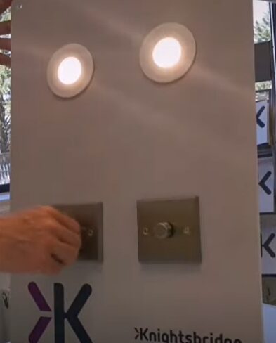 A man showing the switches of a light in a display room