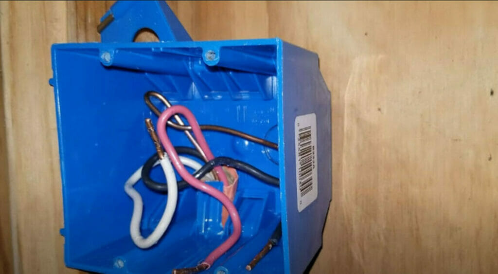 A blue electrical box with wires attached to it