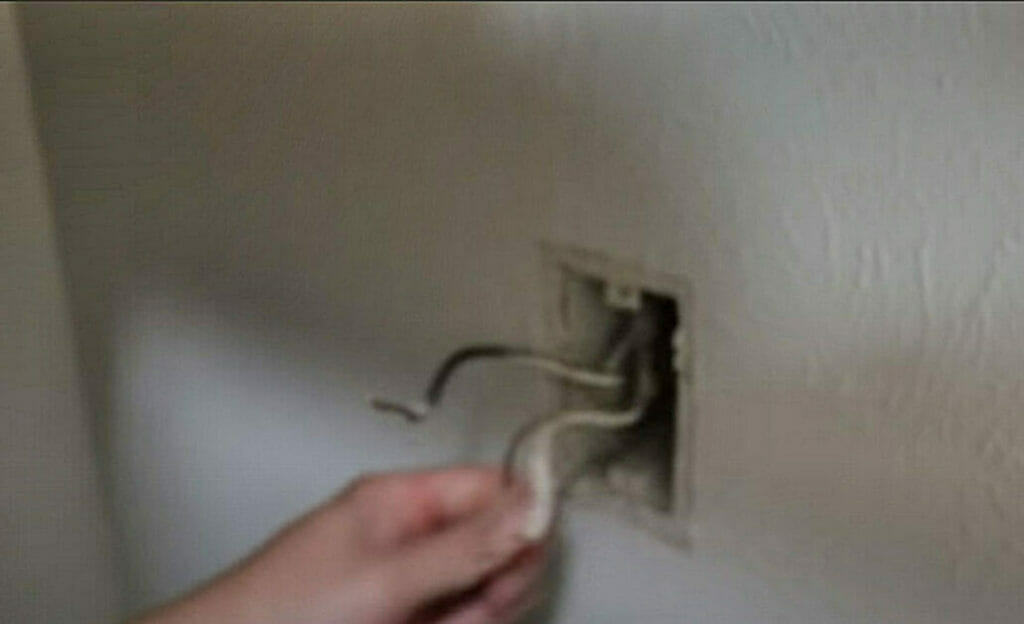 A person preparing the wires for the dryer outlet