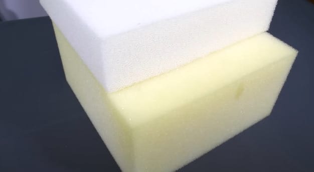 A white and yellow foam sponge on top of each other