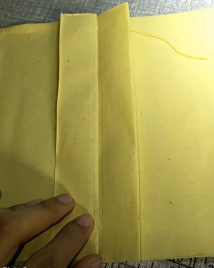 A person is preparing a yellow clothe for sewing