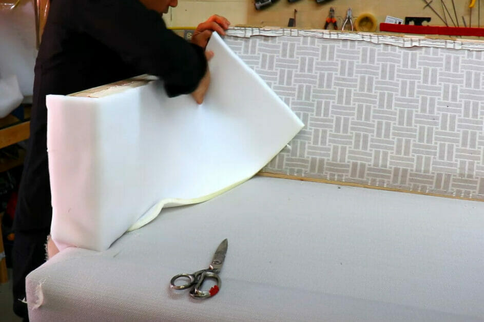 A person cutting a foam for a sofa during upholstery