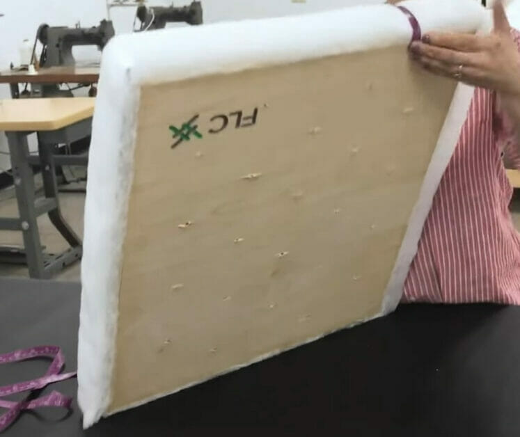 A woman is preparing a large piece of frame with foam in it