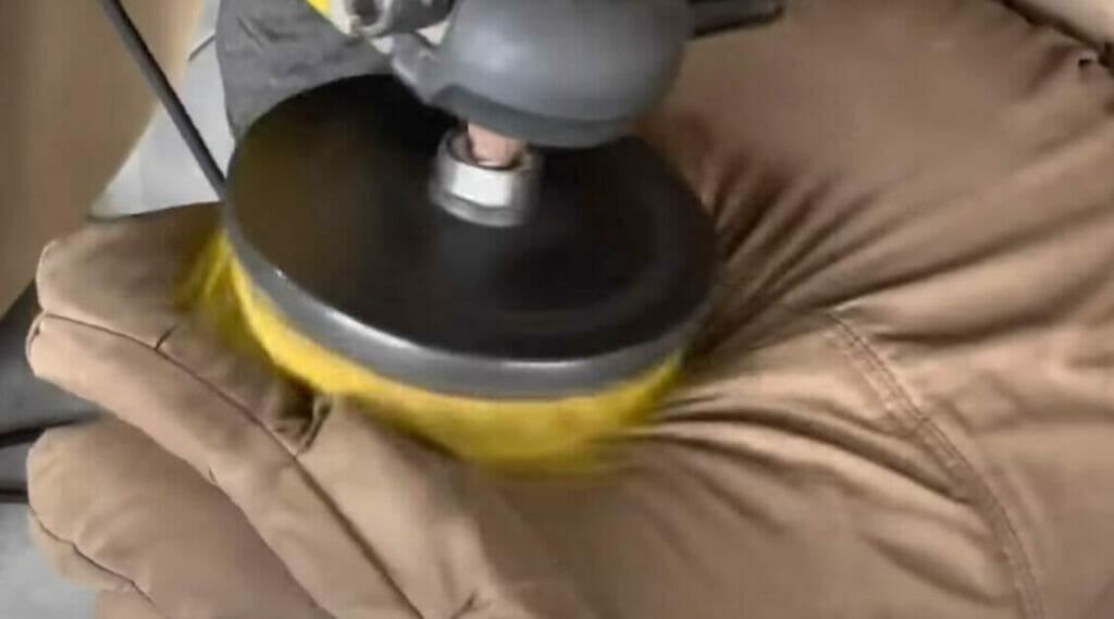 A person cleaning a tufted upholstery