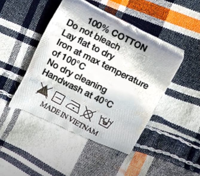 A close up of a plaid shirt label information