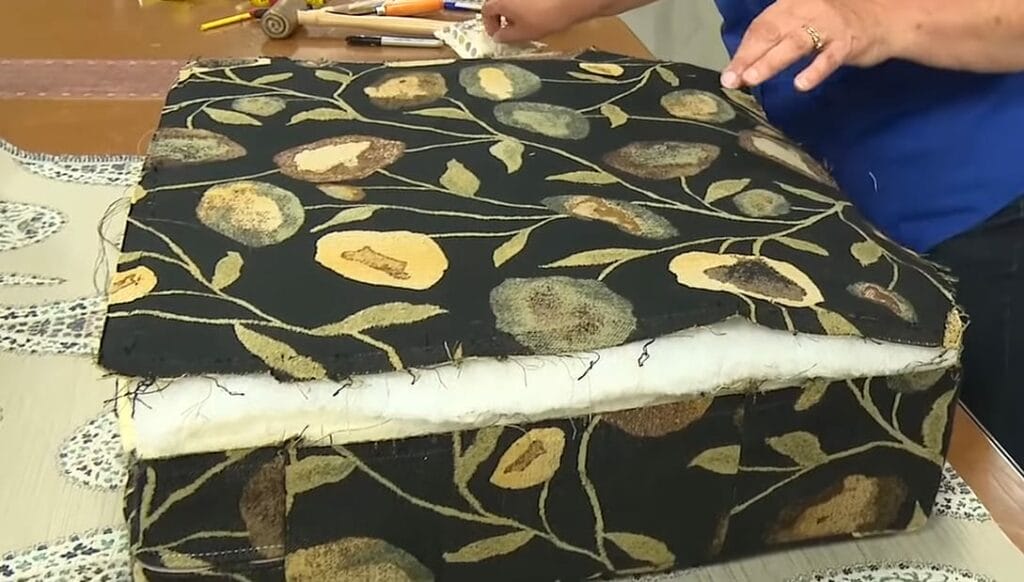 A person doing upholstery on a foam couch