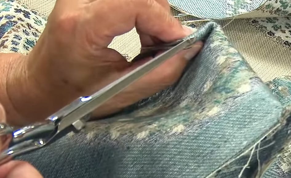 A person cutting fabric using scissor