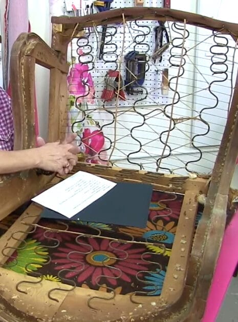 A woman is making a chair out of a wooden frame