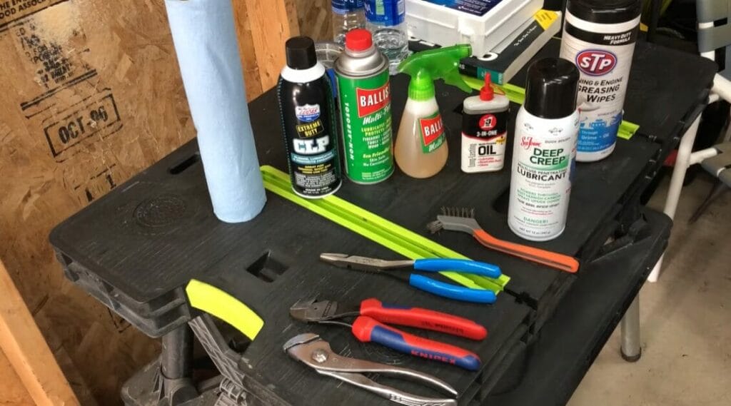 A bottles of different lubricants and adhesives with other tools on the table