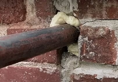 A hole with a pipe being sealed