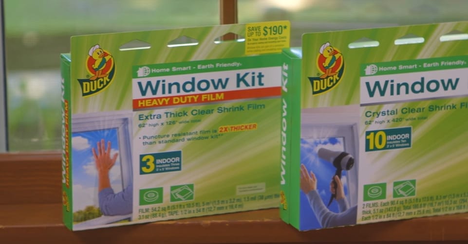Two packages of window kits sitting on a window sill