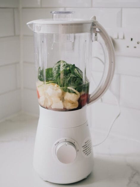 A blender filled with greens and spinach