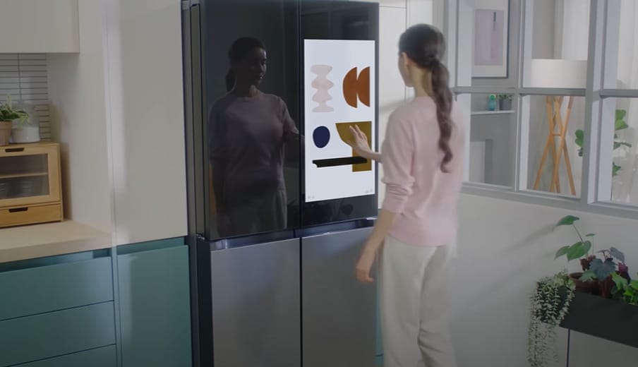 A woman is standing in front of a refrigerator
