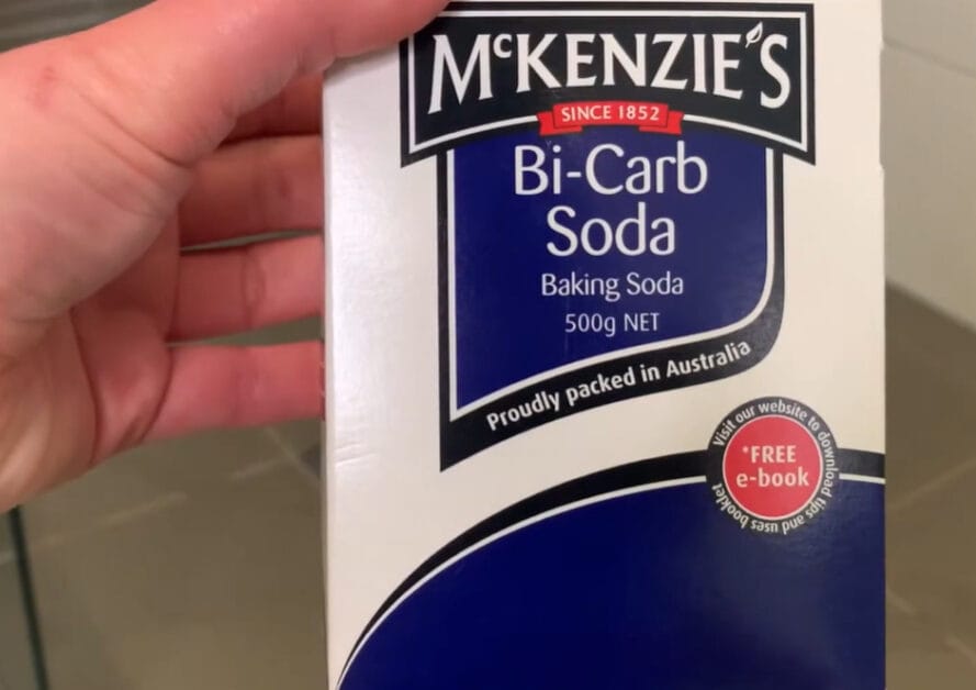 A person holding a McKenZie's Bi-Carb Soda box