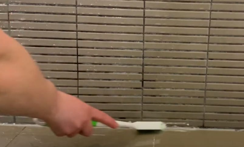 A person brushing the surface with baking soda