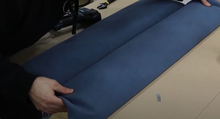 A person unrolling a fabric for upholstery