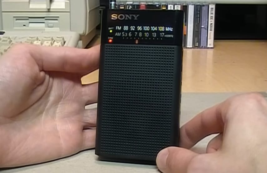 A person holding a pocket radio