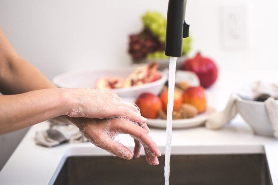 A woman washing her hands in the kitchen sink