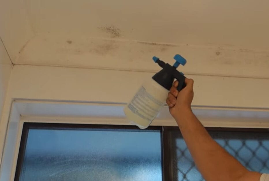 A person spraying the dirty ceiling