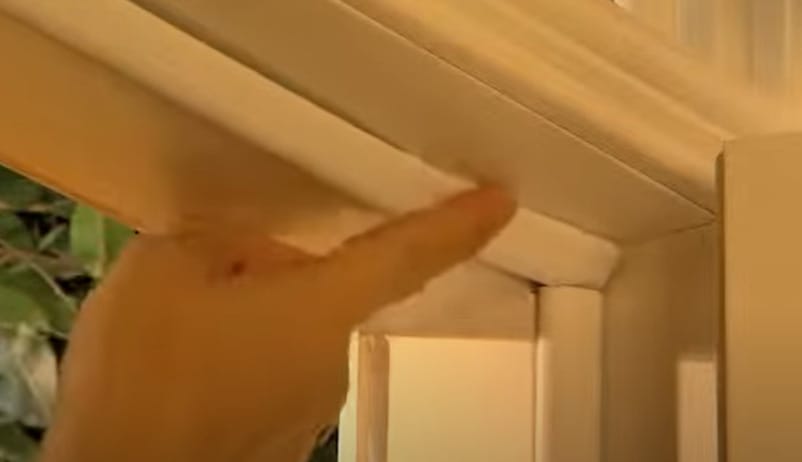 A person attaching weatherstripping to the door