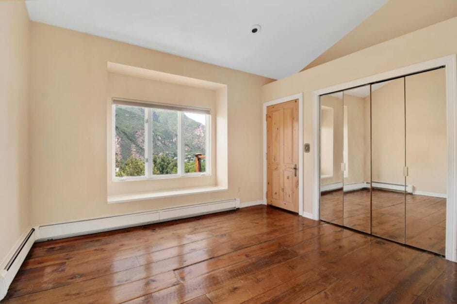 A serene room with hardwood floors, big mirrors and a picturesque view of the mountains