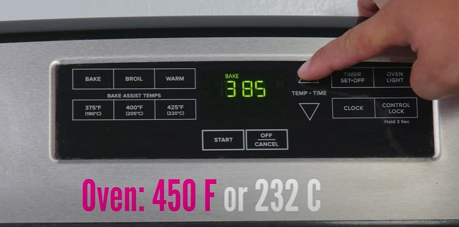 A person preheating an oven in 385 C