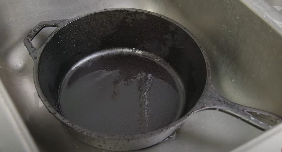 A wet iron cast pan at the kitchen sink