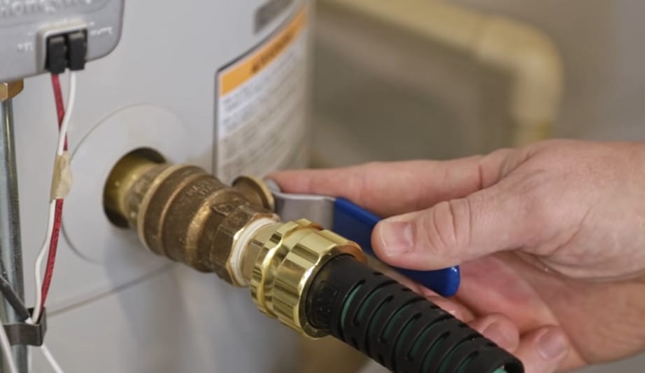 A person is performing a simple repair on a water heater