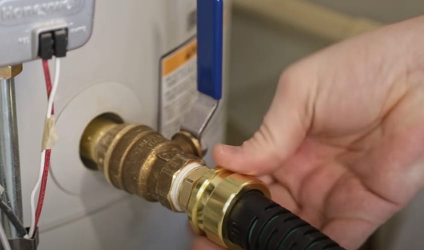 A person is prolonging the life of a water heater by repairing it with a hose