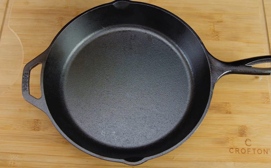 a cast iron pan at the top of a wood chopping board