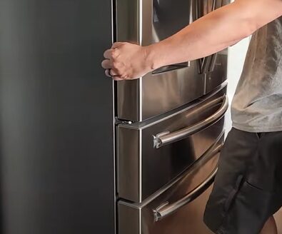 A man opening the door of a stainless steel refrigerator