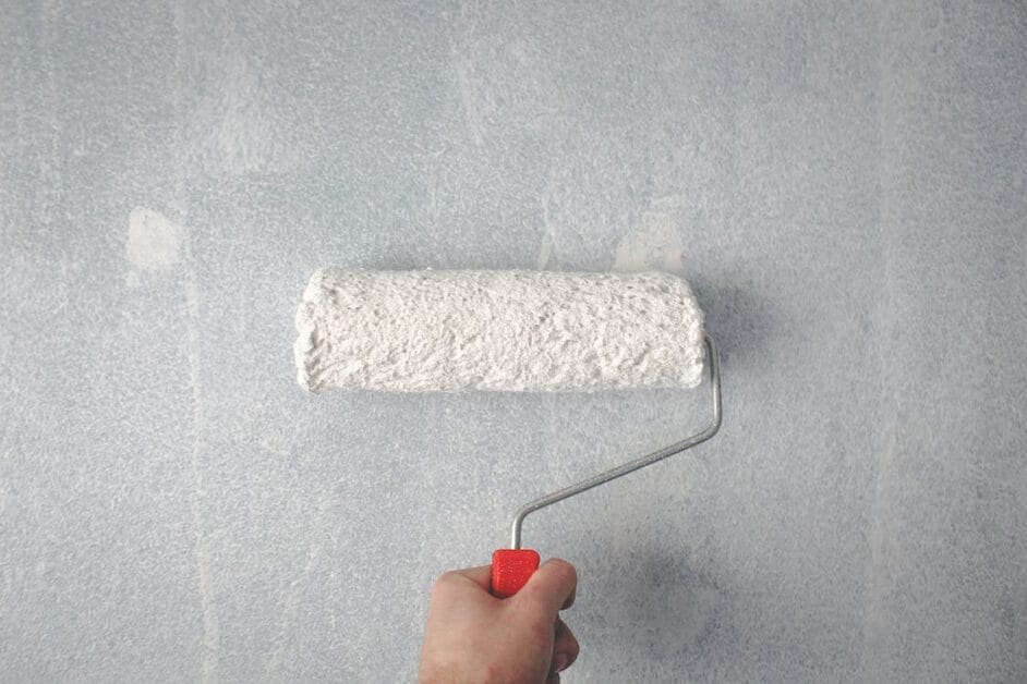 A person painting a wall using a roller