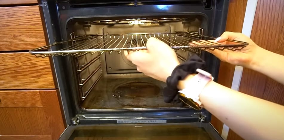 A person putting the tray of an oven