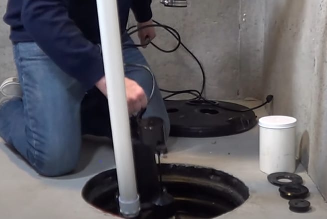 A man installing a sump pump in his basement