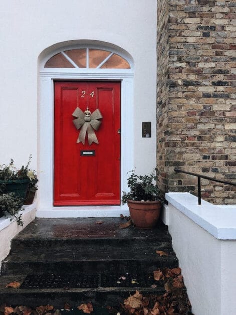 A red door adorn with a Christmas ribbon