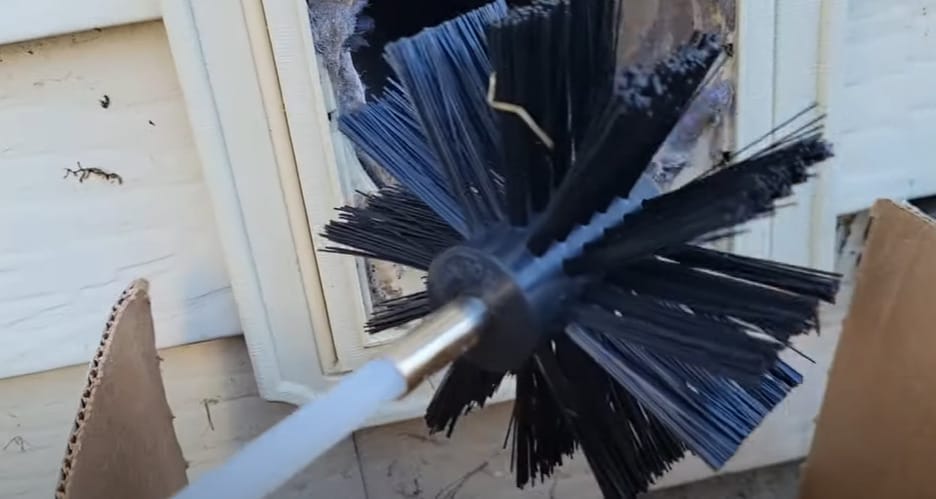 A black broom brush to clean a window
