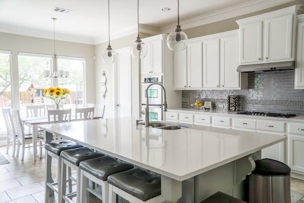 A spotless kitchen with white cabinets and a center island