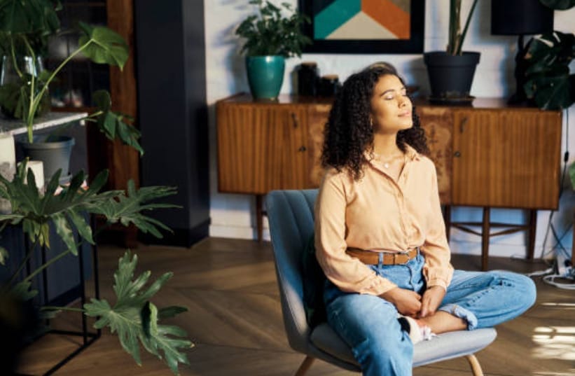 A woman sitting in a chair and meditating