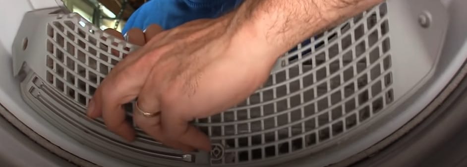 A man putting back the lint trap after cleaning