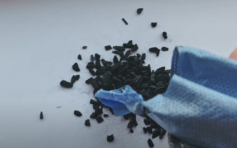 An activated charcoal being poured on the table from a blue bag