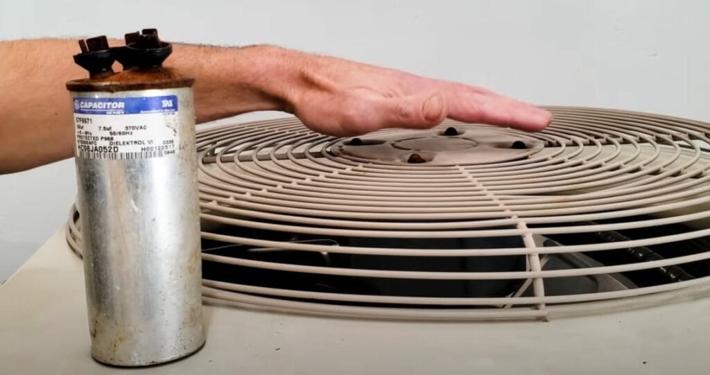 A person's hand on top of an AC