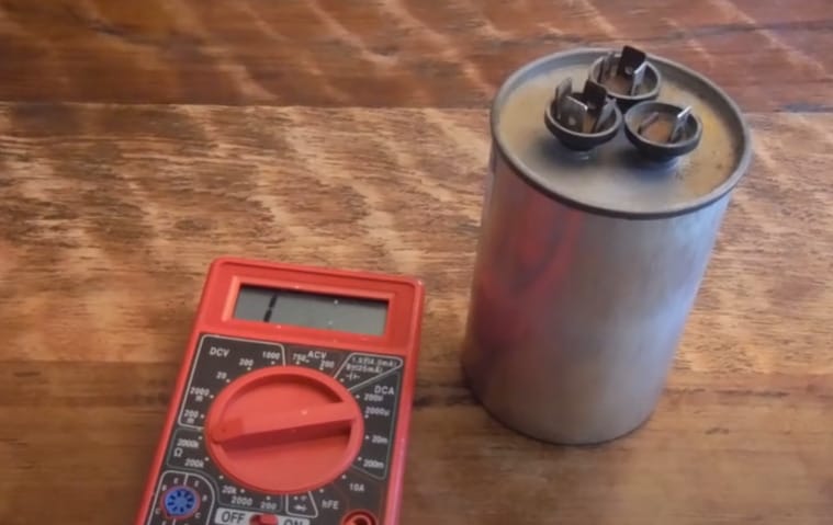 A multimeter and capacitor in a wooden table