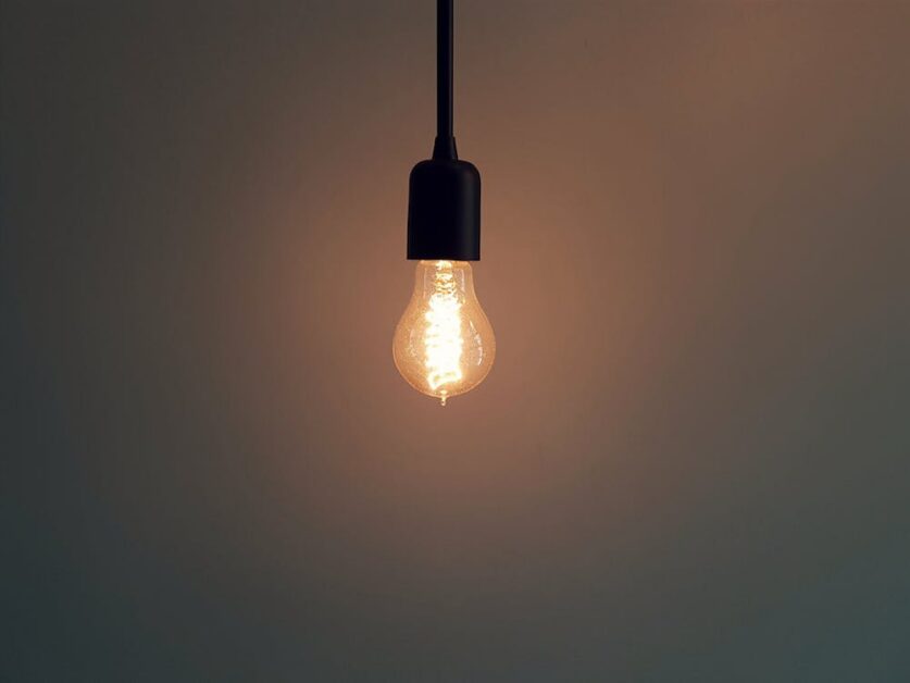 A warm light bulb hanging in a room