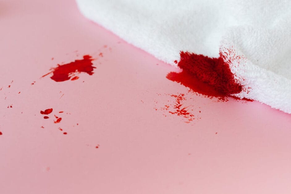 A white towel in a pink surface with blood stains on it